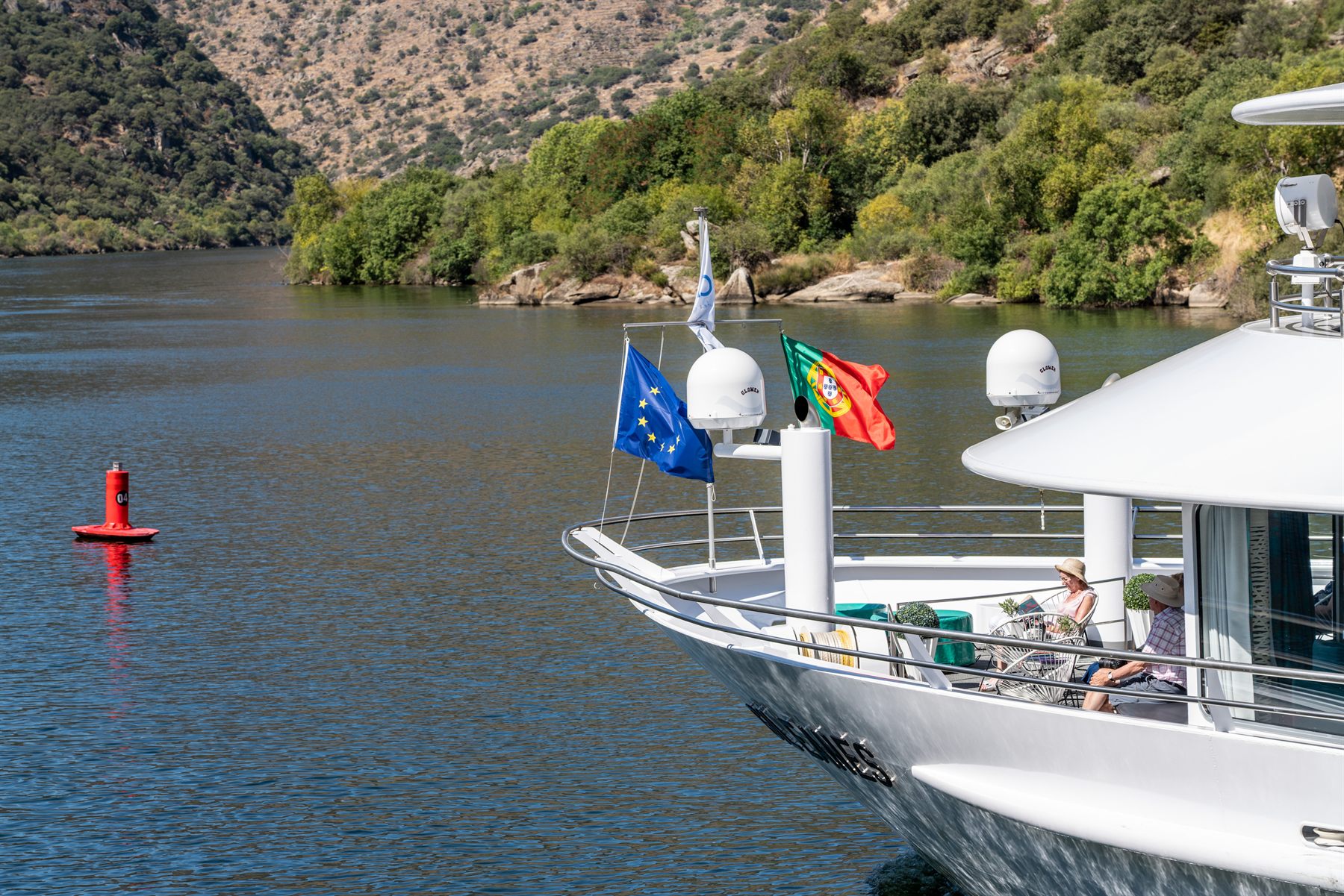 Bow of a river ship flying the Portuguese flag in the Douro valley